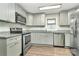 Well lit kitchen features stainless steel appliances, light gray cabinets, granite counters and wood-look flooring at 2520 Lower Stone Church Rd, Rockwell, NC 28138