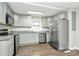 Well lit kitchen features stainless steel appliances, light gray cabinets, granite counters and wood-look flooring at 2520 Lower Stone Church Rd, Rockwell, NC 28138