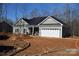 Newly built home with gray siding, two-car garage, and a spacious front yard at 3015 Buffet Ln, Monroe, NC 28110