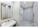 Modern bathroom featuring a frameless mirror, pedestal sink, and glass-enclosed shower at 3319 Gresham Pl, Charlotte, NC 28211