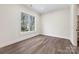 Empty bedroom featuring hardwood floors, a large window, and neutral paint at 3319 Gresham Pl, Charlotte, NC 28211