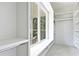 Bright closet features custom built-in shelving, storage, and a window seat with beautiful outdoor view at 3319 Gresham Pl, Charlotte, NC 28211