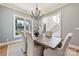 Cozy dining room featuring a wooden table, upholstered chairs, chandelier, and views into the foyer at 3319 Gresham Pl, Charlotte, NC 28211