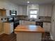 Modern kitchen with island, white cabinets, and hardwood floors at 4165 Laurelwood Ct, Concord, NC 28025