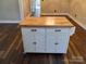 White kitchen island with butcher block top and storage at 4165 Laurelwood Ct, Concord, NC 28025