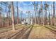 House nestled amongst tall trees in a wooded lot at 5510 Brickstone Dr, Charlotte, NC 28227