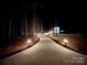 Long driveway leading to a home at night, lit by lights at 5700 Mcwhorter Rd, Waxhaw, NC 28173