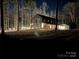 Night view of a modern farmhouse with a large covered porch at 5700 Mcwhorter Rd, Waxhaw, NC 28173