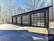 Three-car garage with modern glass paneled doors at 5700 Mcwhorter Rd, Waxhaw, NC 28173