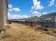 Backyard view shows a black fence, well-maintained lawns, and neighboring houses under a blue sky at 571 Palmarosa St # 130, Fort Mill, SC 29715