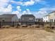 View of backyard featuring black fence and neighboring homes under a bright blue, partly cloudy sky at 571 Palmarosa St # 130, Fort Mill, SC 29715