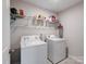 Bright laundry room features a white washer and dryer, plus wire shelving for ample storage space at 571 Palmarosa St # 130, Fort Mill, SC 29715