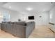 Open concept living room with gray sectional sofa and light wood floors at 693 Candela Ct, York, SC 29745