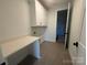 Well-lit laundry room featuring white cabinets, a quartz countertop, and tiled floors at 8704 Sherrills Ford Rd, Sherrills Ford, NC 28673