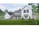 Two-story farmhouse with white and beige siding, a large garage, and landscaping at Lot #6A Otis Crosby Rd, York, SC 29745