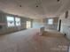 Spacious unfinished living room featuring bright windows and a sliding glass door to the backyard at 1020 Farm Branch Ct, Indian Trail, NC 28079