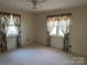 Bedroom with carpeted floor, ceiling fan and floral curtains at 147 W Mcneely Ave, Mooresville, NC 28115