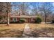 Ranch style brick home with red door and mature trees at 147 W Mcneely Ave, Mooresville, NC 28115