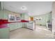 Retro kitchen boasts pale green cabinets and red countertops, offering a vintage feel at 147 W Mcneely Ave, Mooresville, NC 28115