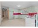 A galley-style kitchen with pale green cabinets and red countertops at 147 W Mcneely Ave, Mooresville, NC 28115