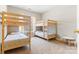 ' bedroom with twin bunk beds, neutral walls, tan carpet, and a small table at 15613 Glen Miro Dr, Huntersville, NC 28078