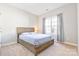 This bedroom features neutral walls, carpet floors, and a natural wood frame bed and headboard at 15613 Glen Miro Dr, Huntersville, NC 28078