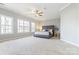 Expansive bedroom features natural light, neutral carpeting and a stylish gray tufted bed frame at 15613 Glen Miro Dr, Huntersville, NC 28078