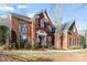 Classic two-story brick home featuring beautiful architectural details and a well-manicured front lawn at 15613 Glen Miro Dr, Huntersville, NC 28078