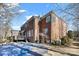 Rear exterior view of brick home with a pool and mature landscaping at 15613 Glen Miro Dr, Huntersville, NC 28078