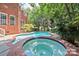 Beautiful in-ground pool and hot tub in a brick surround with mature landscaping in backyard at 15613 Glen Miro Dr, Huntersville, NC 28078