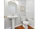 Well-appointed powder room with pedestal sink, framed mirror, and stylish fixtures on hardwood floors at 15613 Glen Miro Dr, Huntersville, NC 28078