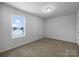 Simple bedroom with neutral walls and carpet flooring at 16115 Preston Knoll Ln, Charlotte, NC 28215