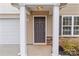 Gray front door entry with white columns and stone accents at 16115 Preston Knoll Ln, Charlotte, NC 28215