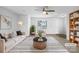 Virtually staged living room with beige sofa and wooden bookcase at 16115 Preston Knoll Ln, Charlotte, NC 28215