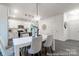 Bright dining room with white table and gray chairs, adjacent to the kitchen at 1739 Dunloe St # 8242, Charlotte, NC 28206