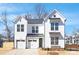 A charming two-story white home with a manicured lawn and a two-car garage, perfect for modern living at 1739 Dunloe St # 8242, Charlotte, NC 28206