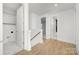 Bright hallway featuring hardwood floors, white trim, and access to various rooms at 1739 Dunloe St # 8242, Charlotte, NC 28206