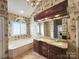 Bathroom with soaking tub, double vanity, and decorative wallpaper at 210 Classic Ct, Mount Holly, NC 28120