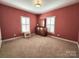 Bedroom with two windows, neutral colored walls and carpet at 210 Classic Ct, Mount Holly, NC 28120