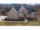 Brick home with gray roof, landscaping, and a paved driveway at 210 Classic Ct, Mount Holly, NC 28120