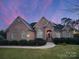 Brick home with landscaped yard and walkway at 210 Classic Ct, Mount Holly, NC 28120