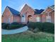 Brick home with landscaped yard and walkway at 210 Classic Ct, Mount Holly, NC 28120