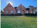 Brick house with manicured lawn and landscaping at 210 Classic Ct, Mount Holly, NC 28120