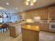 Kitchen features butcher block island, stainless steel appliances, and tile flooring at 210 Classic Ct, Mount Holly, NC 28120