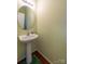 Small half bathroom with pedestal sink and round mirror at 2519 Early Flight Dr, Charlotte, NC 28262