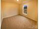 Spacious carpeted bedroom with a large window at 310 Ann Baker Ct, Charlotte, NC 28217