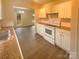 Modern kitchen with white cabinets, granite countertops, and view of dining area at 310 Ann Baker Ct, Charlotte, NC 28217