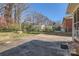 Large backyard with a concrete patio, mature trees, and a chain-link fence at 4017 Leeds Dr, Charlotte, NC 28205