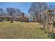 Large backyard featuring a wooden bench swing, a detached shed, and mature trees at 4017 Leeds Dr, Charlotte, NC 28205