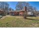 View of brick house, detached shed, patio area, and large grassy backyard at 4017 Leeds Dr, Charlotte, NC 28205